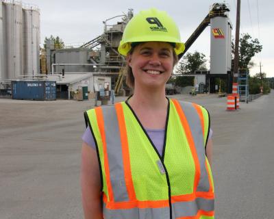 Asphalt Academy Graduate standing at paving equipment